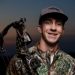 High school senior wearing camo and holding a bow